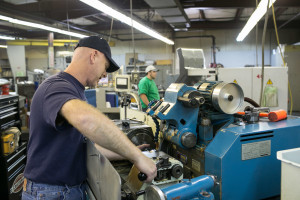 Two successful job applicants working on precision grinding equipment