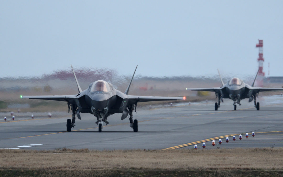 Two military aircraft landing on a runway.