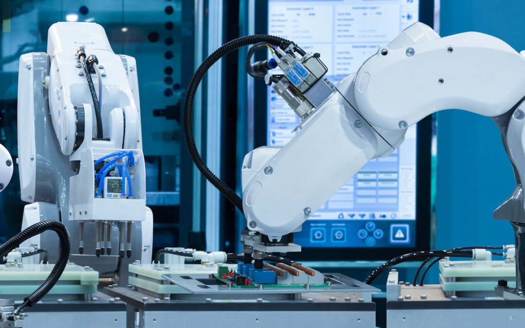 Automated robotic assembly systems use white robotic arms to produce manufactured goods.