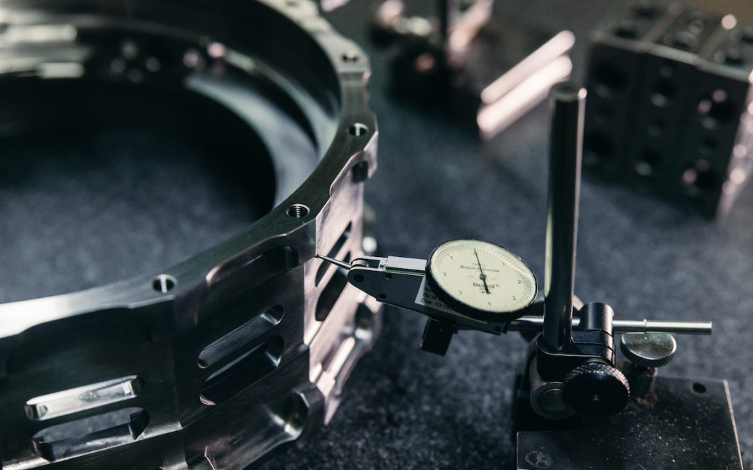 A measuring gauge touches the edge of a precision grinding workpiece.