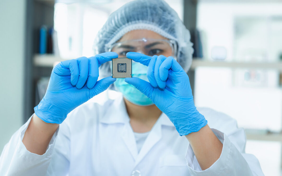 A computer engineer is holding CPU's computer for examination, a part of the production of semiconductors.